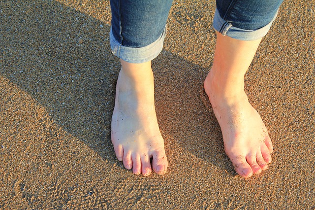 Πόδια που περπατανε γυμνα στην αμμο